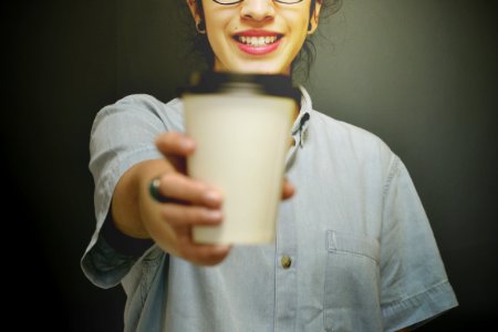 woman holding white and black coffee cup photo