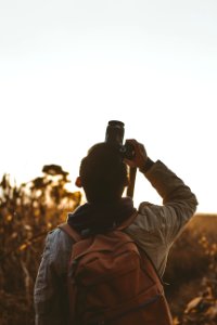 man taking picture using DSLR camera photo