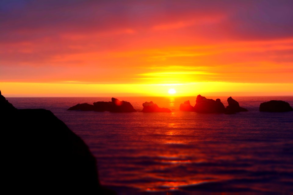 rocks on sea under sunset
