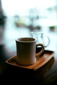 beige mug on top of brown wooden tray photo