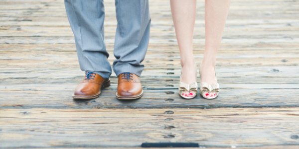 man wearing brown leather oxford shoes beside woman wearing gold open-toe sandals photo