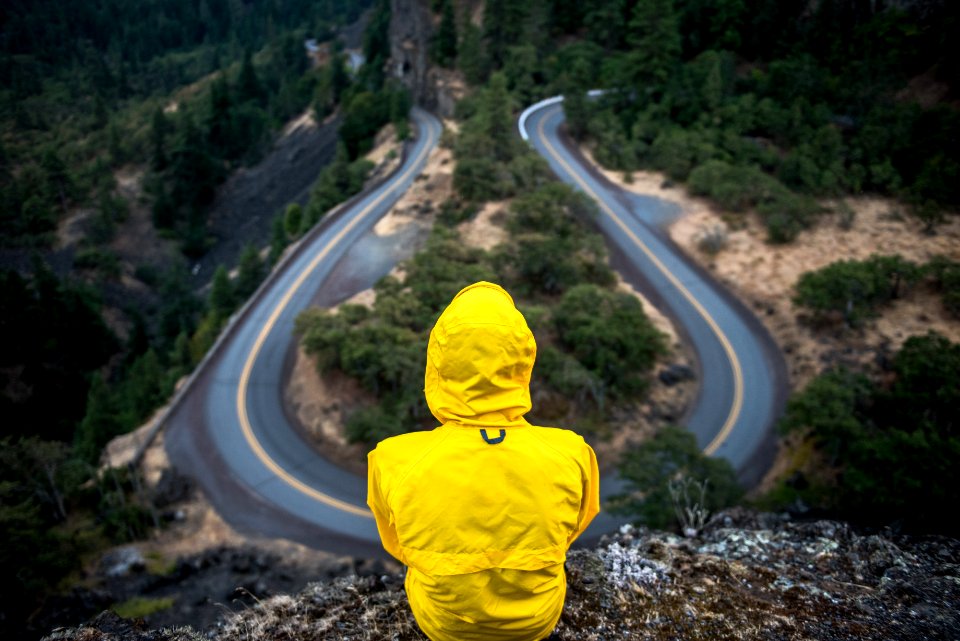person in yellow coat standing on top of hill