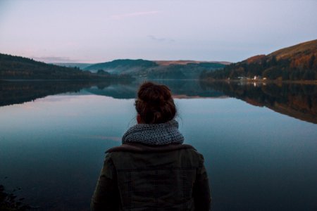 woman standing in front of body of water during dawn photo
