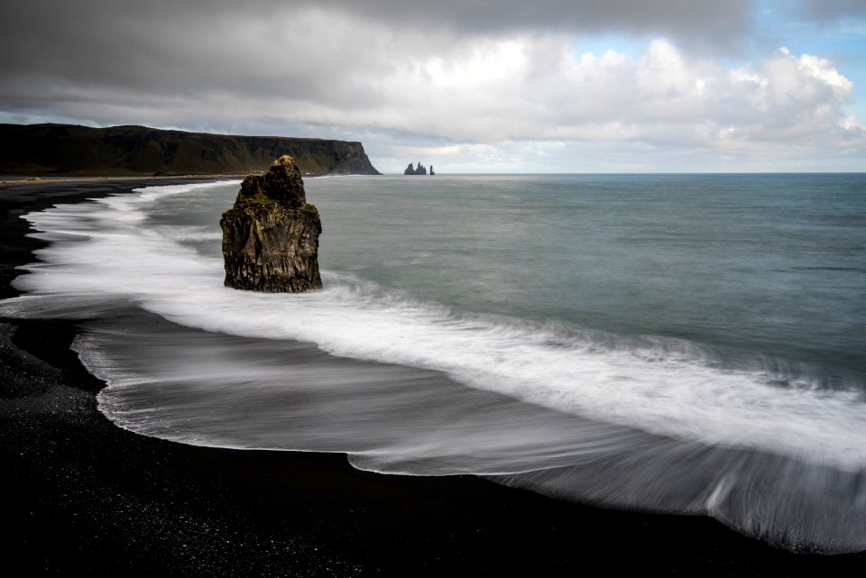 brown rock on seashore under white clouds at daytime photo