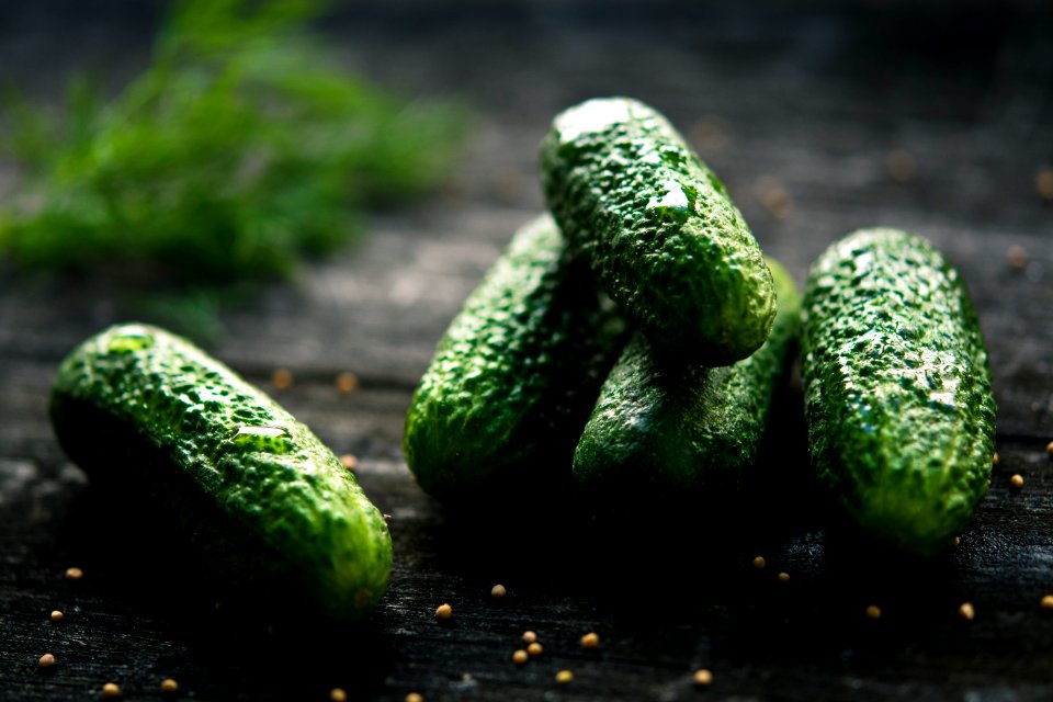 3 green cucumbers on black wooden table