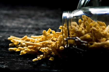 close up photo of yellow spiral pasta spilled jar