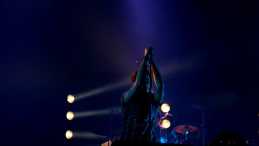 person holding mike up high on dim light