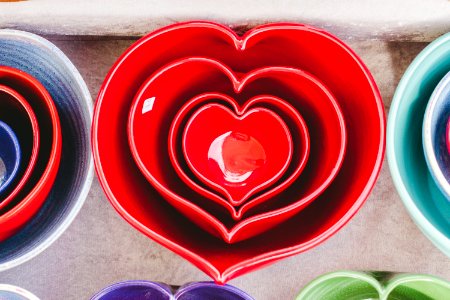 Red heart-shaped ceramic bowls of different sizes stacked one inside the other