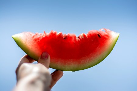 person holding sliced watermelon photo