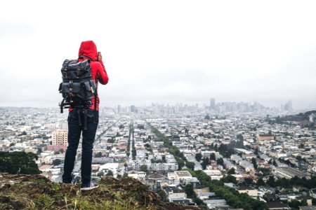 person standing on cliff over city photo