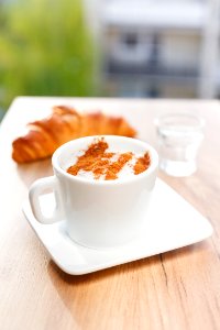 flat lay photography of white mug on white saucer plate and croshan bread