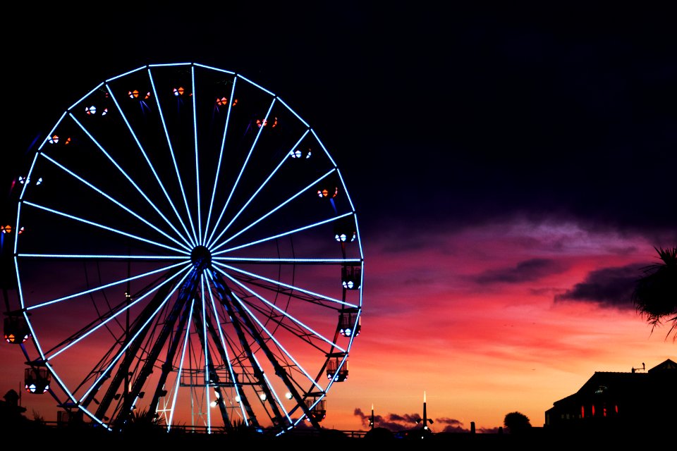 silhouette photography of lit-up ferris wheel during golden hour