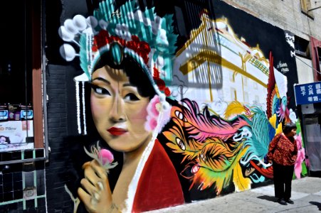 An Asian woman holding a flower, painted on a wall. photo