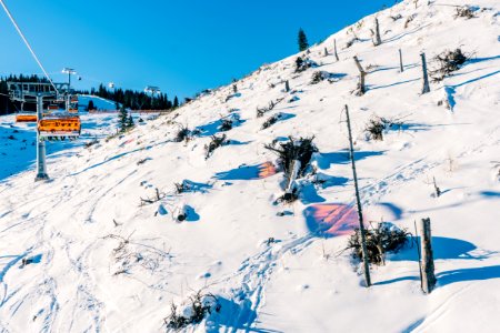 people riding ski lift on snow covered mountain during daytime photo