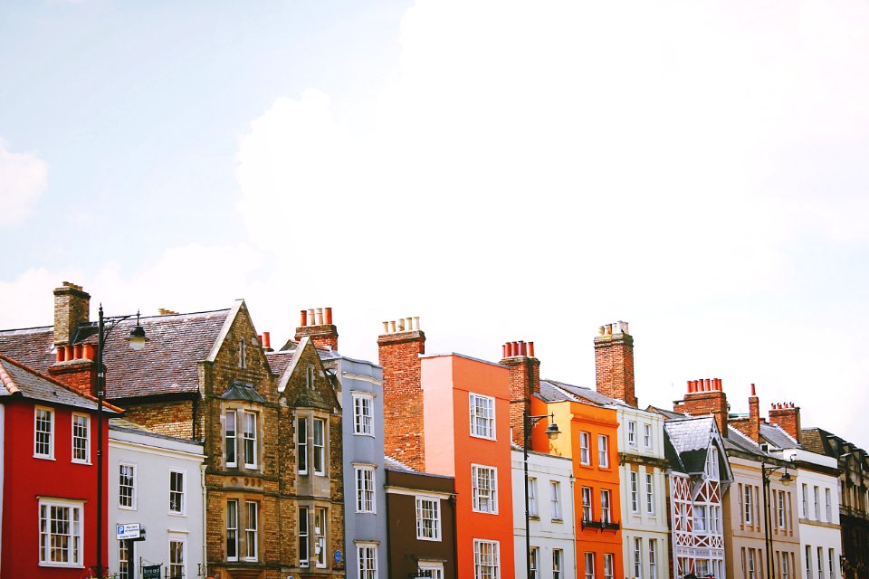 assorted-color concrete houses under white clouds during daytime
