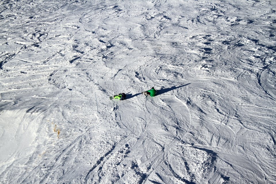 person sitting on snow covered field