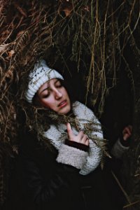 woman under arc of dried leaves holding scarf photo