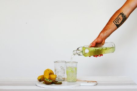 person pouring juice on glasses on table photo