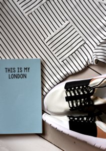 pair of white-and-black sneakers beside book photo