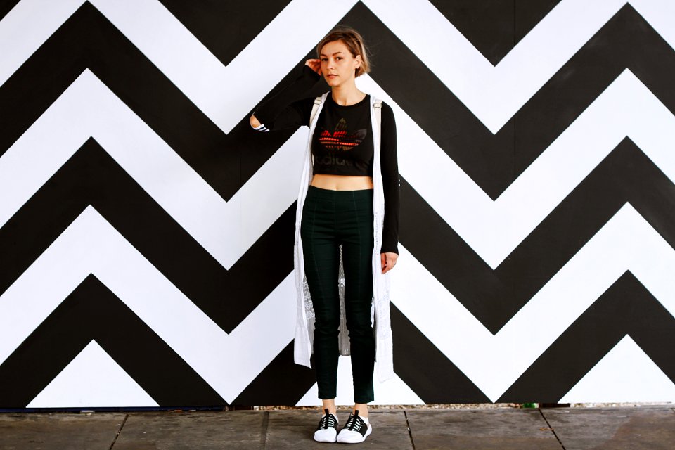woman standing beside white and black chevron wall