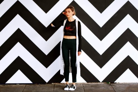 woman standing beside white and black chevron wall photo