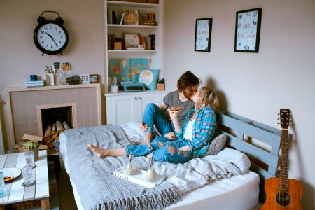 man and woman kissing on bed photo