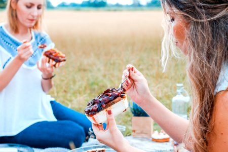 two people eating cake on blue blanket photo