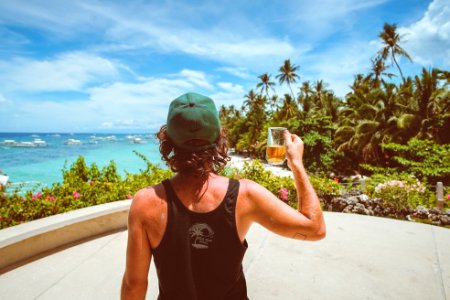 man in black tank top holding clear drinking glass photo