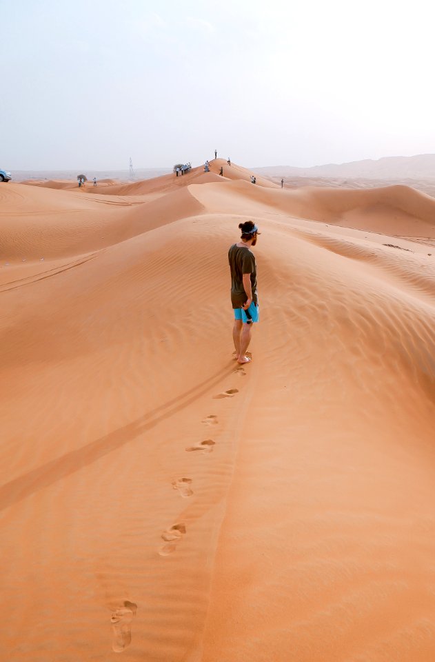 person standing on sand dune