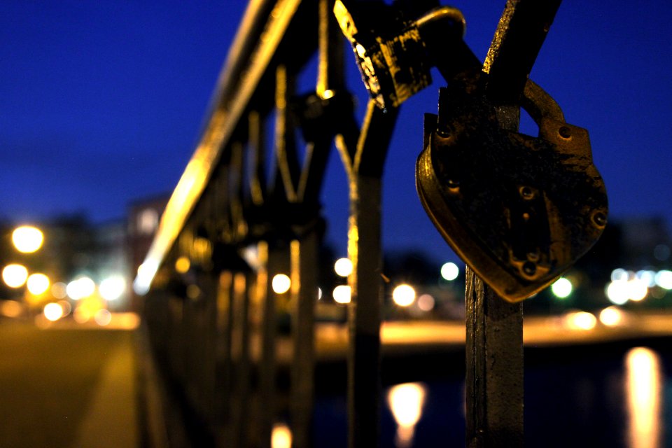 blue padlock on black metal fence during night time