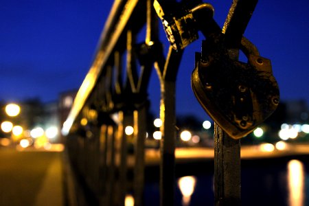 blue padlock on black metal fence during night time
