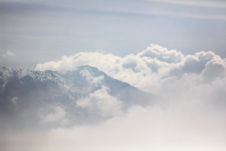 white clouds over snow covered mountain photo