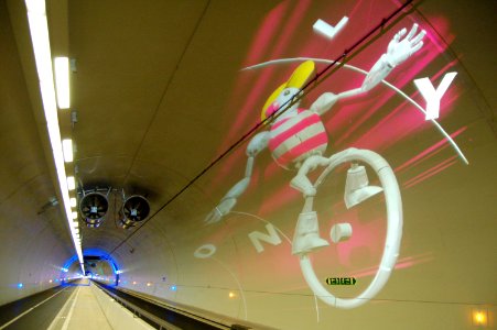 A white character on a unicycle displayed on the ceiling of a tunnel.