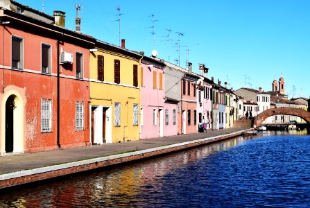 assorted-color painted houses beside body of water' photo