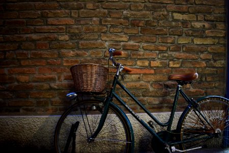 black cruiser bike with basket parked beside wall photo