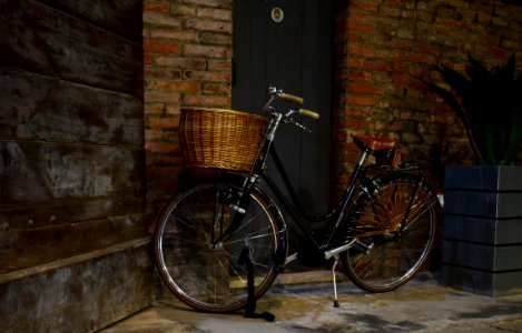 black city bike beside brown brick wall photo