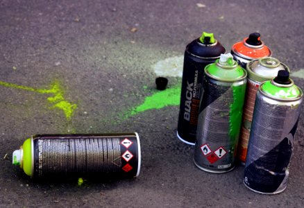 Used spray cans sitting on the ground.