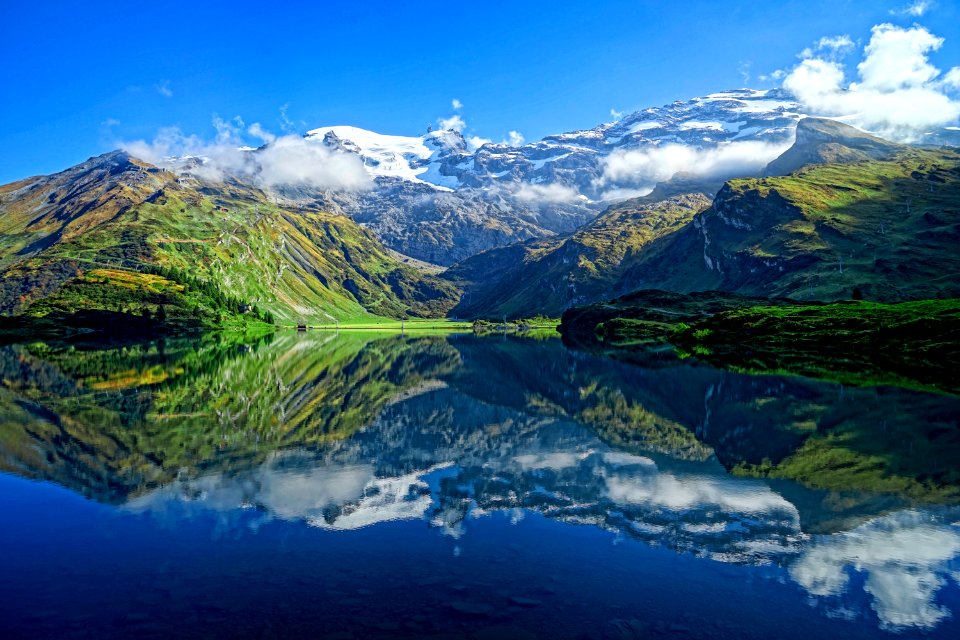 lake viewing mountain under blue and white skies