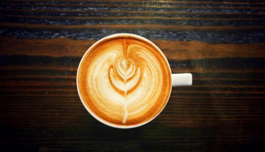 cup of cappuccino on brown surface photo