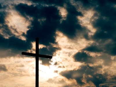 silhouette of cross under cloudy sky photo