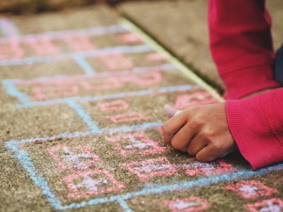 person holding chalk lying on concrete surface photo