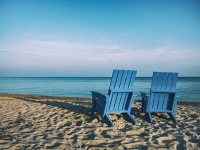 two blue beach chairs near body of water photo