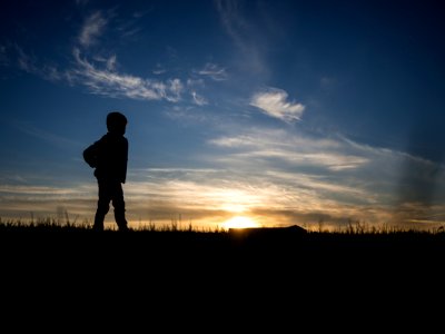 silhouette of person standing on grass field photo