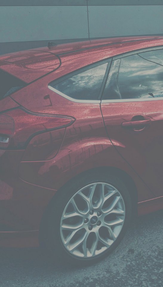A red hatchback parked.