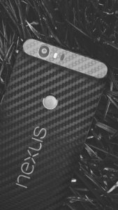 A black Nexus phone on the ground.