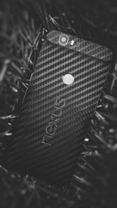 A black Nexus phone sitting on the ground.