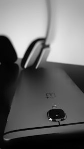 A black smartphone near headphones.