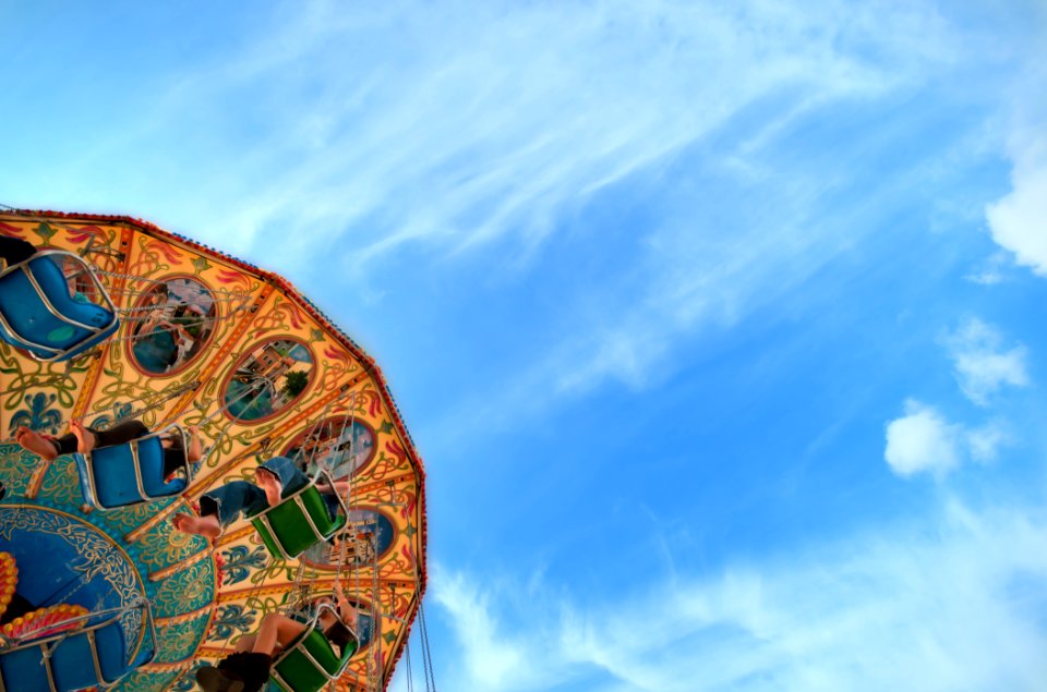 low angle photo of brown, green, and blue carousel under cloudy sky