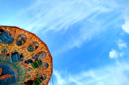 low angle photo of brown, green, and blue carousel under cloudy sky