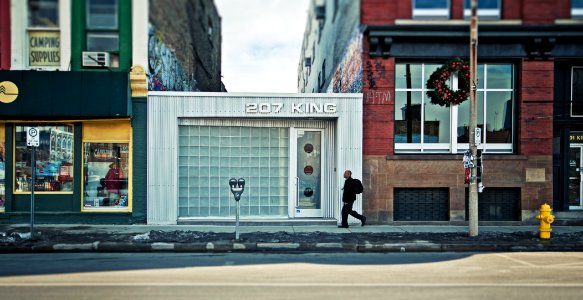 man walking beside 207 King building during daytime photo